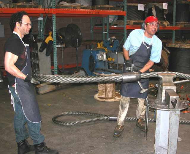 Two workers manufacturing a lifting sling